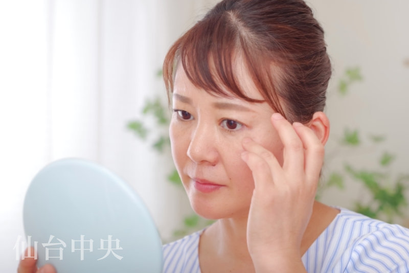 目頭切開が失敗して鏡を見る女性