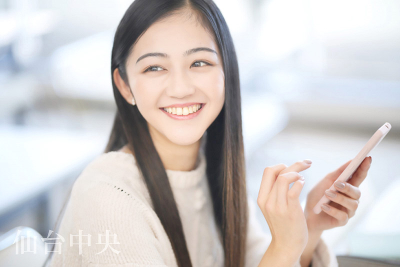 スマートフォンで美容整形の格安価格を検索する女性